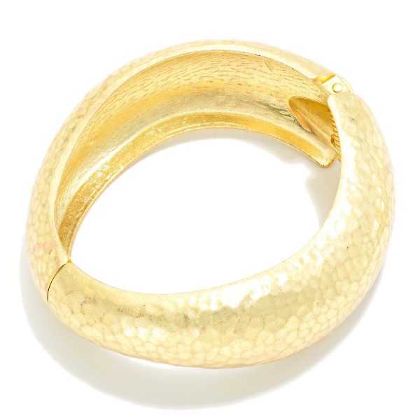 Hammered Wide Hinged Bangle Bracelet featuring a domed band with an all over hand hammered texture. The hinged closure makes it easy to put on and keeps it secure throughout the day. Bold enough to wear alone and easy to pair with thinner bangles and watches. A timeless statement bangle that appeals to a wide range of customers and makes a polished gift.