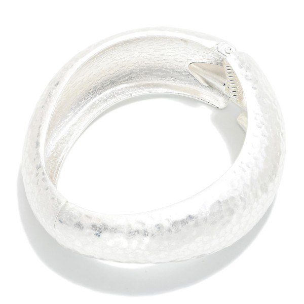 Hammered Wide Hinged Bangle Bracelet featuring a domed band with an all over hand hammered texture. The hinged closure makes it easy to put on and keeps it secure throughout the day. Bold enough to wear alone and easy to pair with thinner bangles and watches. A timeless statement bangle that appeals to a wide range of customers and makes a polished gift.