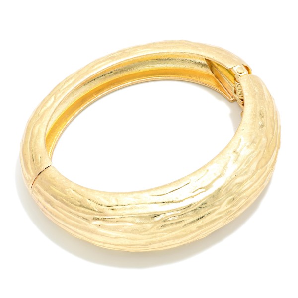 Textured Hinged Bangle Bracelet with a chunky domed profile and an etched, bark inspired finish that catches the light. The hinged design opens for easy wear and closes securely. A bold statement piece that pairs beautifully with sweaters, button downs, and evening looks. A polished bracelet at an approachable price, ideal for gifting and for customers who love substantial metal jewelry.