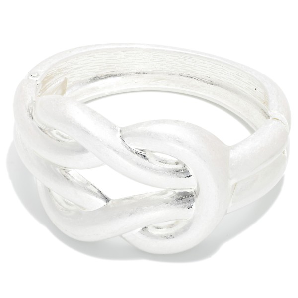 Knot Hinged Bangle Bracelet featuring a sculptural knotted centerpiece on a wide brushed band. The hinged design opens for easy wear and closes securely for a comfortable fit. A bold yet polished statement piece that pairs with the coordinating knot earrings for a complete look. Ideal for gifting and for customers who love chunky, modern metal jewelry.
