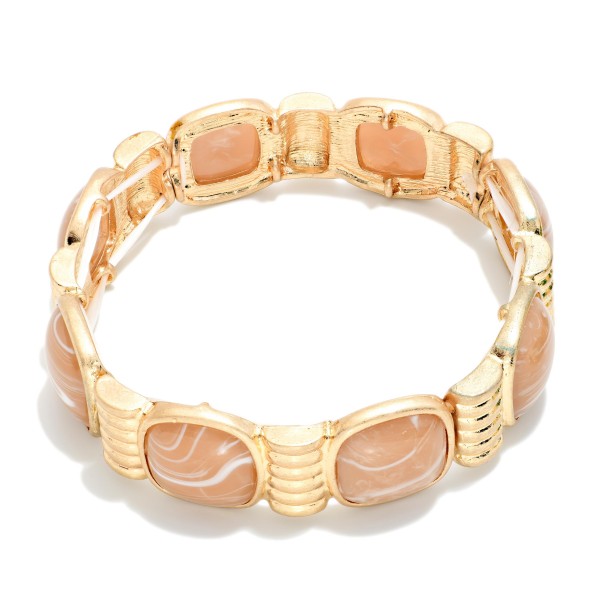 Marbled Stone Stretch Bracelet featuring cushion cut stones with a swirled, glossy finish set between ribbed metal spacers. The stretch fit slides on easily and sits comfortably on most wrists. The bold stones give it a vintage inspired, statement look that pairs well with knits and holiday dresses. Offered in several stone options, it's an easy seller for stacking and coordinating displays.