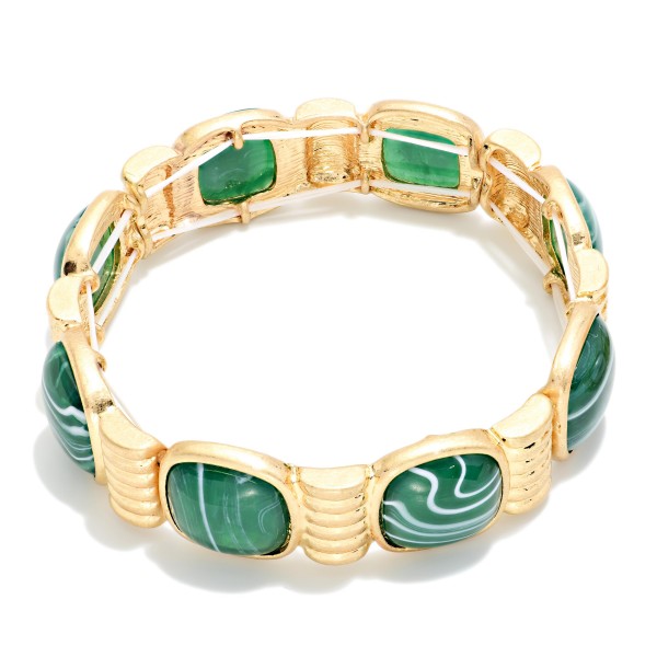 Marbled Stone Stretch Bracelet featuring cushion cut stones with a swirled, glossy finish set between ribbed metal spacers. The stretch fit slides on easily and sits comfortably on most wrists. The bold stones give it a vintage inspired, statement look that pairs well with knits and holiday dresses. Offered in several stone options, it's an easy seller for stacking and coordinating displays.