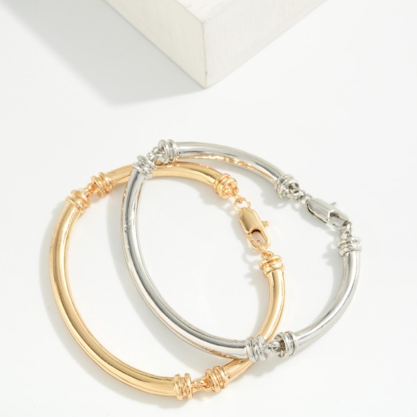 Polished Tube Hinged Bangle Bracelet with a smooth, rounded profile and ribbed accents at the hinge. The hinged design opens wide for easy on and off and closes securely. A clean, classic bangle that stacks well with watches, beaded stretch bracelets, and charm styles. Timeless and versatile, it's an easy everyday seller for customers of all ages.