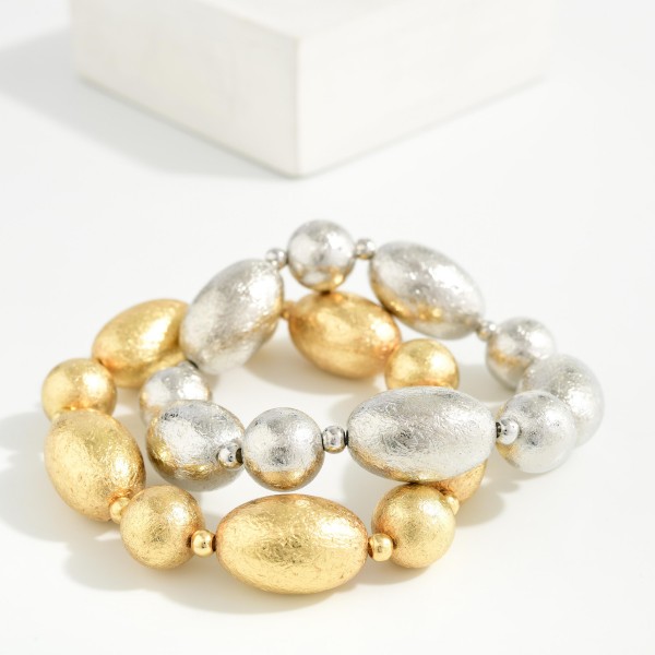 Textured Metal Bead Stretch Bracelet with oversized oval beads finished in a brushed, ridged texture for subtle shine. The stretch fit slips on easily and makes a bold statement on its own or stacked with other bracelets. Great for work, weekends, and holiday outfits. A modern, versatile metal bracelet that appeals to a broad range of customers and sells well all year.