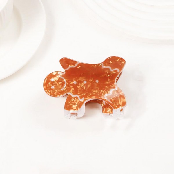 Holiday-shaped claw hair clip molded in glossy acrylic with hand-painted seasonal detail and a glitter-flecked finish. Strong-grip teeth hold a twist, a half-up, or a full clip-up on fine and thick hair alike, so it works for everyday wear and not just the party. A natural stocking stuffer, teacher gift, and secret-santa filler that buyers grab in multiples. Small footprint and low price point make it an easy counter or holiday-display add.