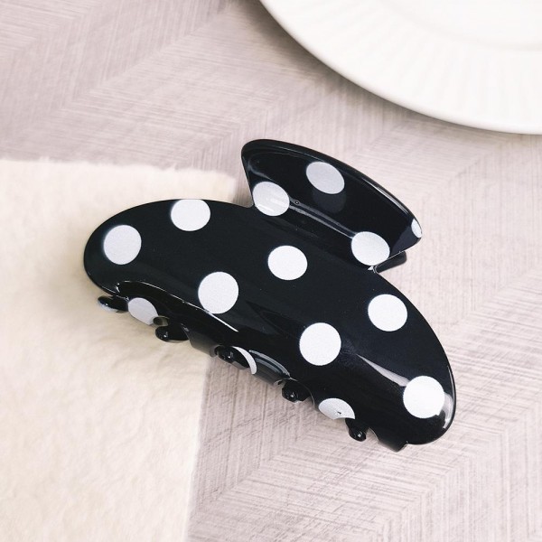 Polka dot claw hair clip in smooth acrylic with contrast painted dots and a mid-size profile. Strong-grip teeth hold a twist, a half-up, or a full clip-up on fine and thick hair alike without pulling or sliding out. Polka dots are a perennial retro print that pairs just as easily with denim and knits as with workwear. A steady everyday seller at an impulse price, and an easy multiple for customers building a clip collection.