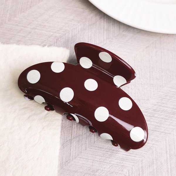 Polka dot claw hair clip in smooth acrylic with contrast painted dots and a mid-size profile. Strong-grip teeth hold a twist, a half-up, or a full clip-up on fine and thick hair alike without pulling or sliding out. Polka dots are a perennial retro print that pairs just as easily with denim and knits as with workwear. A steady everyday seller at an impulse price, and an easy multiple for customers building a clip collection.