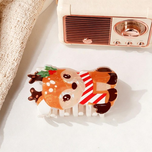 Reindeer claw clip molded in glossy acrylic with antler detailing and a candy striped scarf across the front. The teeth grip a half up twist or a small bun and stay put through a full day. The character shape reads immediately, which is what makes these sell off a display rather than needing a pitch. An easy stocking stuffer at an impulse price.