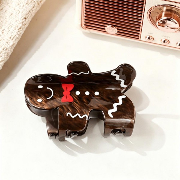 Gingerbread man claw clip molded in glossy acrylic with piped icing detailing and a candy button front. The clip holds a half up twist or pins back a fringe, and the character shape reads instantly across a room. Sturdy teeth grip thick hair without needing a second clip. Holiday character clips are the kind of small treat customers add on without thinking twice.