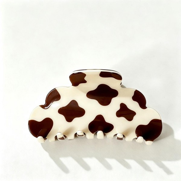 Cow Print Claw Hair Clip with a playful spotted pattern on a smooth, glossy acrylic body. The rounded cloud shape and strong spring hinge grip medium to thick hair for a quick twist, half up look, or messy bun that stays put all day. A trendy pick for western inspired outfits, rodeo season, country concerts, and everyday wear. Easy to merchandise by the dozen, these fun printed clips are a quick impulse buy that customers love to collect.