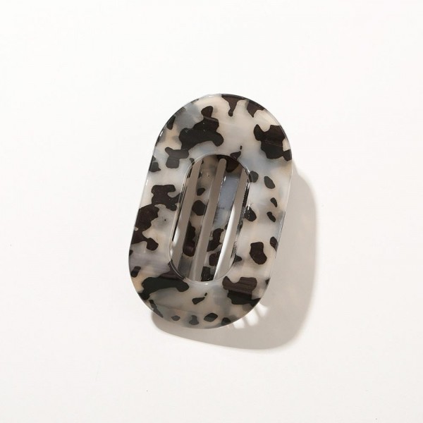 Oval hair barrette cut from marbled acrylic with a hidden snap bar that clicks closed over a half up style, a low ponytail, or a loose braid. The resin pattern shifts across the face so no two pieces look exactly alike. Smooth edges keep it from catching on fine hair and it sits flat against the head all day. Marbled barrettes read expensive on a display and move quickly at an impulse price.
