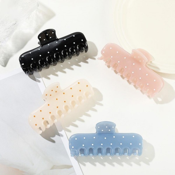 Dotted claw clip in a soft matte acrylic with a wide jaw and long teeth that hold thick hair in a single twist. The scattered dot print keeps it playful without being loud, so it works for the office as easily as a weekend. A smooth finish means no snagging when it comes back out at the end of the day. Printed claw clips are a dependable impulse item that customers buy in multiples.