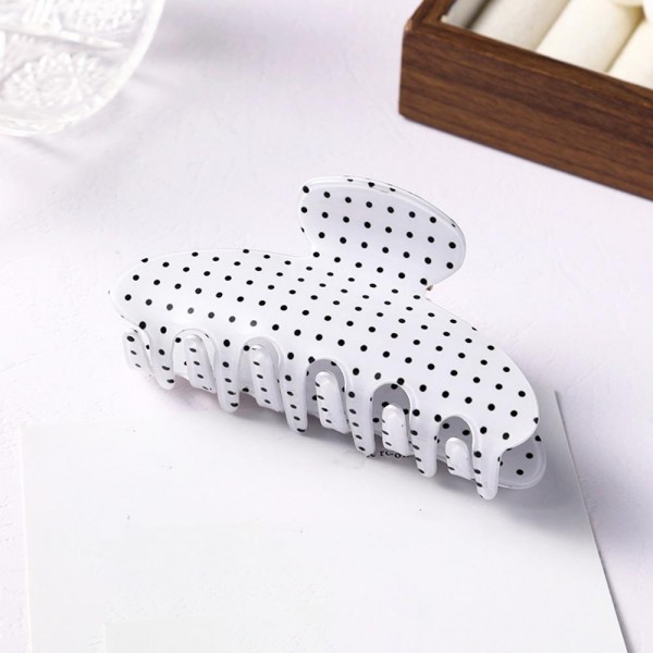 Polka dot claw clip molded in glossy acrylic with deep interlocking teeth and a strong spring that holds a full twist without slipping. Wide enough for thick hair yet slim enough to keep a low profile at the back of the head. The printed finish dresses up a work bun or a wet hair day in a single motion. Printed claw clips are an easy impulse pickup and they reorder consistently.