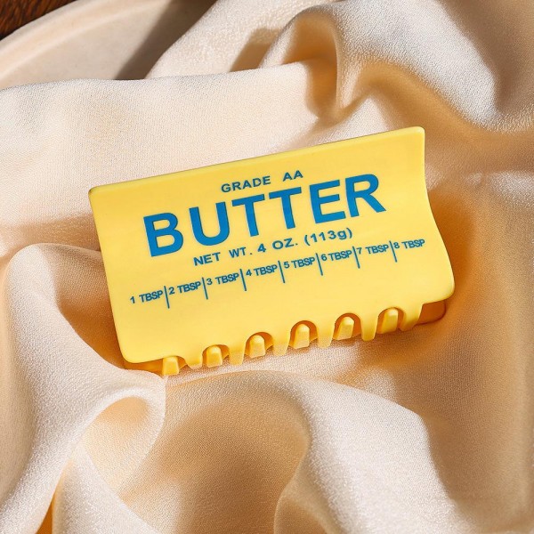 Novelty butter stick hair claw clip molded in glossy acrylic with a printed wrapper detail and a sturdy hinge that grips a full twist of hair. The playful shape gets noticed on a shelf and reads as a gift even when someone buys it for themselves. Strong enough for thick hair and light enough to wear while working at a desk. Novelty claw clips move fast on a counter display and customers rarely buy just one.