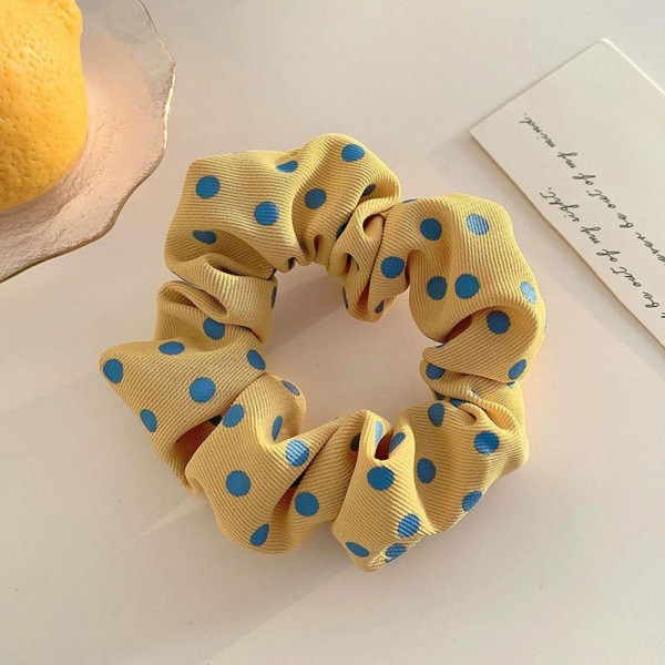 Polka dot scrunchie in a soft chiffon style fabric with a generous gathered body that grips without pulling. The wide covered elastic holds a ponytail or a bun securely and slides out without leaving a crease. A printed take on an everyday essential that customers collect and replace rather than buy once. Scrunchies at this price are the definition of an impulse add at the register.