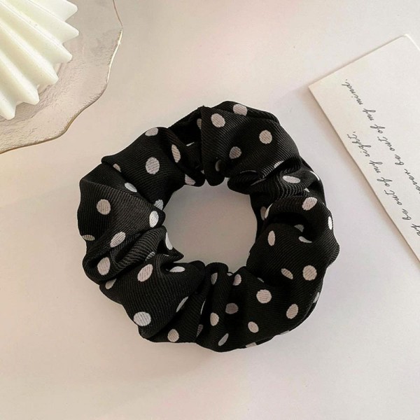 Polka dot scrunchie in a soft chiffon style fabric with a generous gathered body that grips without pulling. The wide covered elastic holds a ponytail or a bun securely and slides out without leaving a crease. A printed take on an everyday essential that customers collect and replace rather than buy once. Scrunchies at this price are the definition of an impulse add at the register.