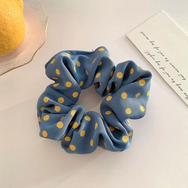 Polka dot scrunchie in a soft chiffon style fabric with a generous gathered body that grips without pulling. The wide covered elastic holds a ponytail or a bun securely and slides out without leaving a crease. A printed take on an everyday essential that customers collect and replace rather than buy once. Scrunchies at this price are the definition of an impulse add at the register.