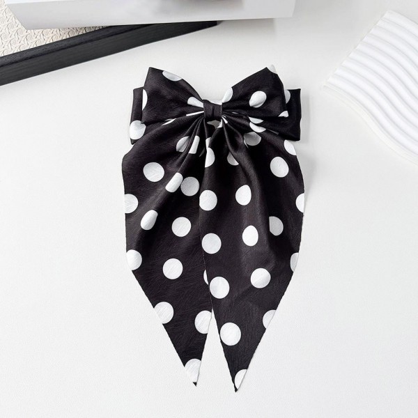 Long tail bow hair clip with a polka dot print and a secure snap base that grips fine and thick hair alike. The flowing tails add movement to a low ponytail, a half up style, or a simple braid. A lightweight satin finish keeps it comfortable enough to forget about during a long day. Bow clips like this are an easy impulse pickup and they merchandise well on a peg display.