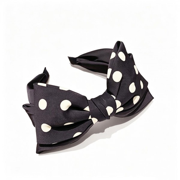 Statement bow headband with a wide polka dot bow tied over a padded band that stays put without digging in. The bow holds its shape through wear, so it still looks crisp at the end of a long day. A fast way to finish a look for showers, holiday parties, and photo sessions without touching the rest of an outfit. Big bow headbands photograph well and move quickly off a counter display.