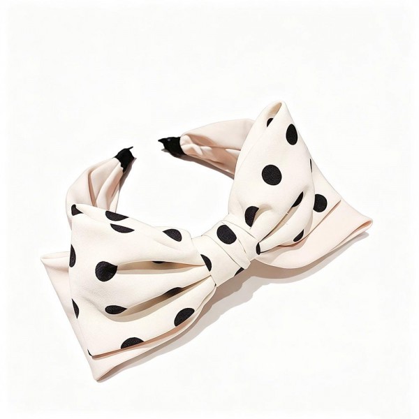 Statement bow headband with a wide polka dot bow tied over a padded band that stays put without digging in. The bow holds its shape through wear, so it still looks crisp at the end of a long day. A fast way to finish a look for showers, holiday parties, and photo sessions without touching the rest of an outfit. Big bow headbands photograph well and move quickly off a counter display.