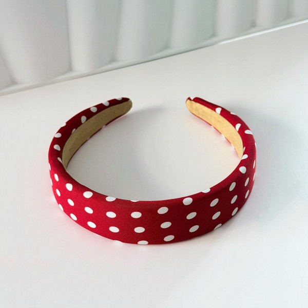 Padded headband with an allover polka dot print and a wide crown that holds hair back without pinching behind the ears. The firm band keeps its shape through a full day and the smooth finish will not snag fine hair. A retro print that dresses up a simple ponytail or a fresh blowout in one step. Headbands like this are a quick impulse add and they photograph beautifully on a display.