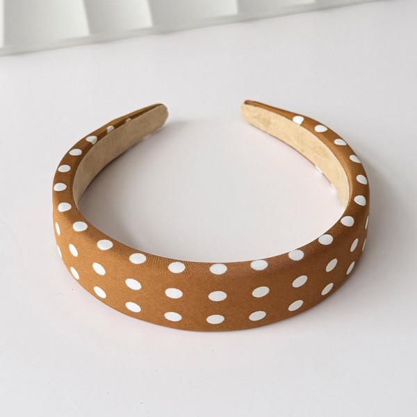 Padded headband with an allover polka dot print and a wide crown that holds hair back without pinching behind the ears. The firm band keeps its shape through a full day and the smooth finish will not snag fine hair. A retro print that dresses up a simple ponytail or a fresh blowout in one step. Headbands like this are a quick impulse add and they photograph beautifully on a display.