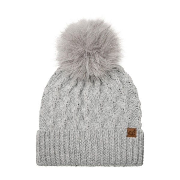 Lattice Cable Knit Pom Beanie with an allover diamond cable texture in a soft heathered yarn, topped with a plush faux fur pom. The ribbed band folds up for a snug double layer over the ears, and a small faux leather patch adds a finished look. A cozy favorite for holiday shopping, tailgates, and snowy weekend walks. Textured pom beanies are a top seller every winter and make an easy, giftable add on at the register.
