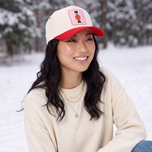 Bring a touch of classic holiday charm to any outfit with this nutcracker patch baseball cap, featuring a framed embroidered nutcracker soldier on a structured front panel paired with a contrast curved brim. A sweet and nostalgic seasonal accent that pairs beautifully with cozy sweaters, puffers, and denim. The adjustable back closure provides a comfortable fit for most head sizes, making it a charming gift and a festive favorite for boutiques and gift shops.
