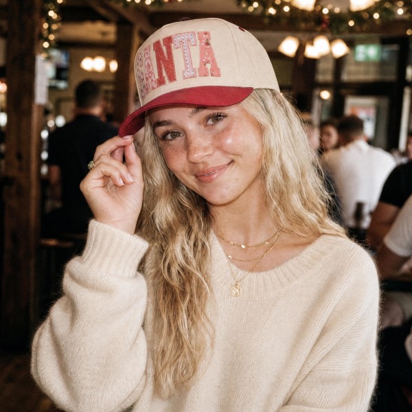 SANTA Baseball Cap with oversized candy stripe letters spelling out SANTA across the front for a bold, playful holiday look. A structured cap with a rich contrast brim that pairs perfectly with cream knits, puffer jackets, and denim. Ideal for Christmas parties, holiday shopping trips, and festive weekend outfits. Statement holiday caps are a trendy seasonal pick that boutique shoppers snap up for themselves and for gifting.