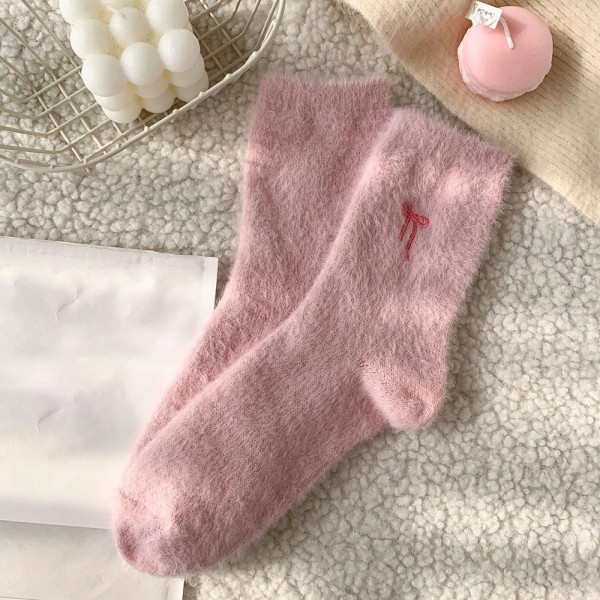 Round out your cozy assortment with this assorted six-pack of plush feather-knit crew socks finished with a tiny embroidered bow at the cuff. Knit from a brushed, fuzzy yarn blend that feels irresistibly soft against the skin, each pair adds the kind of dainty bow detail that fits perfectly into the coquette and soft-girl trend cycle — quick to photograph, quick to reorder. The mid-calf length and stretch ribbed top layer easily under jeans, leggings, and lounge sets. A boutique-perfect pick for bridesmaid gifts, hostess bundles, Valentine displays, and self-care assortments built around small luxuries.