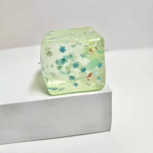 This translucent floral cube squishy toy is a decorative novelty with irresistible shelf appeal. Its soft, clear squeeze body reveals a floating floral confetti design inside, making it as pretty as it is fun to squish. Made from soft, flexible material with a satisfying tactile feel, it appeals to gift buyers, decor enthusiasts, and novelty toy shoppers alike. A standout impulse buy for gift boutiques and novelty retailers — it photographs beautifully and generates strong customer interest.
