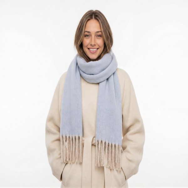 Brushed heavyweight scarf with a soft napped face and fringed ends, cut long enough to wrap twice and still hang past the chest. The dense weave holds warmth on a cold morning without the itch of a coarse wool. A solid finish layers over every coat and every print already on the floor, which makes it an easy pairing sale. Fringed winter scarves are a proven cold weather driver and they gift well with no extra packaging.