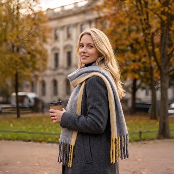 Oversized Plaid Blanket Scarf with soft brushed finish and fringed edges. Generously sized to wear looped, draped, or wrapped as a shawl, it layers beautifully over coats and sweaters for instant cold-weather polish. A fall and winter staple that anchors seasonal displays — boutique customers stock multiple patterns because these fly off the shelf as gifts and self-purchases alike.
