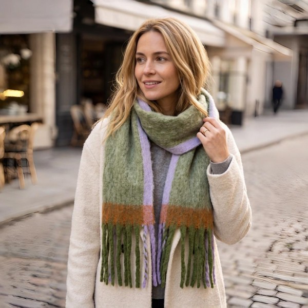 Oversized Plaid Blanket Scarf with soft brushed finish and fringed edges. Generously sized to wear looped, draped, or wrapped as a shawl, it layers beautifully over coats and sweaters for instant cold-weather polish. A fall and winter staple that anchors seasonal displays — boutique customers stock multiple patterns because these fly off the shelf as gifts and self-purchases alike.