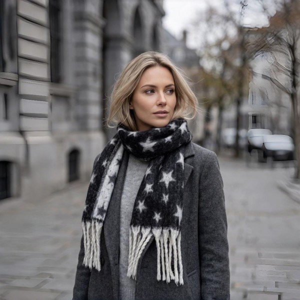 Star Print Fringe Scarf in a soft brushed woven fabric with an allover star pattern and hand knotted fringe ends. Generously sized to wrap, loop, or drape open over a coat, and light enough to keep on indoors. Star prints read festive without being locked to one holiday, so it sells from early fall straight through the new year. A dependable scarf program at a boutique friendly price point.