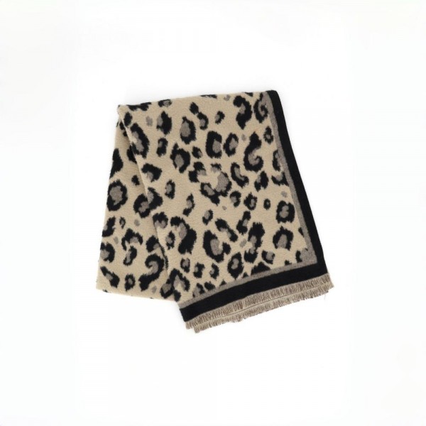Animal print scarf in a soft brushed weave with a solid contrast border and knotted fringe ends. Long wrap length loops twice or drapes open over a coat, and the spotted print carries a neutral outfit on its own. A cold weather staple for boutique buyers stocking travel, tailgates, farmers markets, and holiday gifting. Animal print scarves are a proven repeat seller that never sits on the rack.