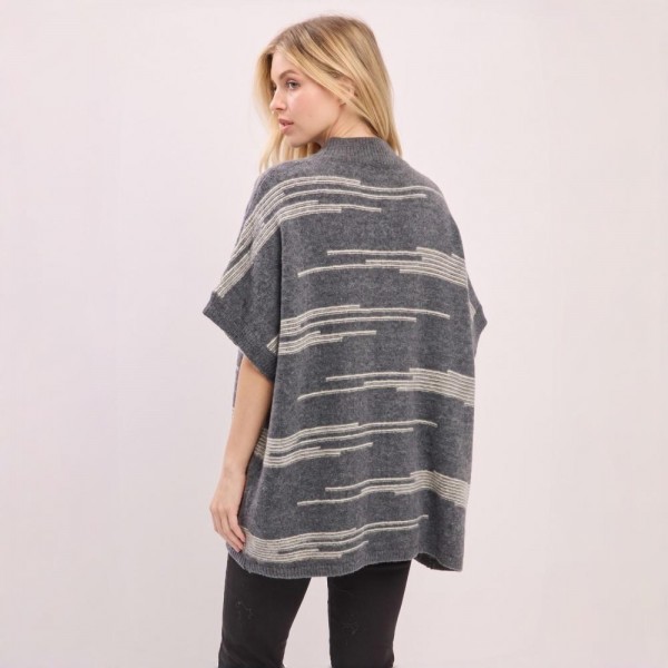 Button front poncho in a brushed blanket knit with a wide contrast stripe and side pockets. One size drape falls past the hip and layers over long sleeves, denim, or leggings without adding bulk. A fall and winter layer for boutique buyers stocking travel, football weekends, church, and cold office mornings. Blanket stripe ponchos read as the statement layer on a mannequin and sell through fast.