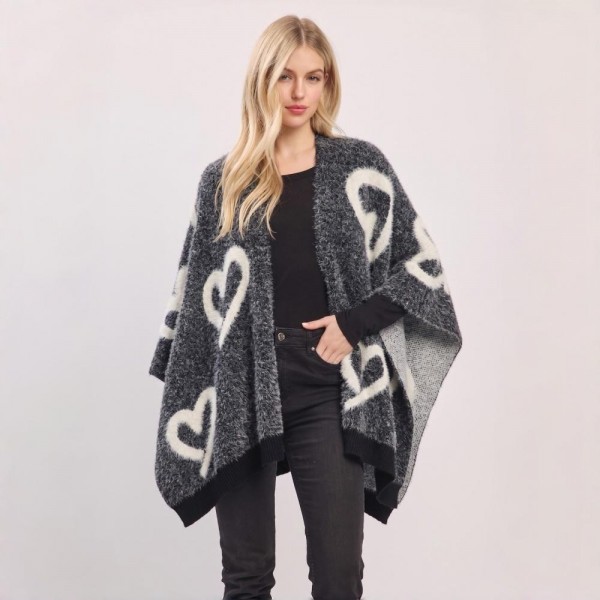 Heart Pattern Knit Ruana Poncho with an open-front silhouette and cozy oversized drape. The soft jacquard knit features an allover heart motif with contrast trim — a one-size layering piece that flatters effortlessly over leggings, denim, or dresses. A statement outerwear piece that photographs beautifully for social posts and sells fast at boutiques as the ultimate cozy gift.