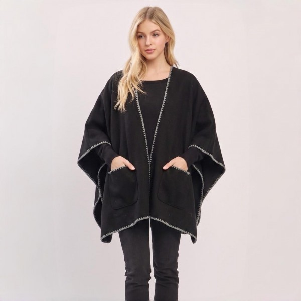 Open front ruana wrap in a brushed knit with patch pockets and contrast blanket stitch along every edge. One size drape falls past the hip, layers over a tee or a turtleneck, and throws on without fussing with buttons. A fall and winter layer for boutique buyers stocking travel, football weekends, church, and cold office mornings. Pocketed ruanas photograph well on a mannequin and sell as the piece that finishes the outfit.