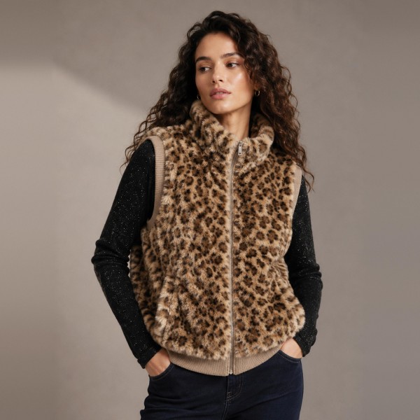 Leopard Print Sherpa Vest with a high stand collar, full zip front, and side pockets. The plush, cozy pile is finished with ribbed knit trim at the armholes and hem for a clean, structured fit. Layer it over a long sleeve tee, turtleneck, or sweater for an easy fall and winter look that works from weekend errands to holiday gatherings. Animal print and sherpa are two of the season's strongest sellers, and this vest puts both into one piece customers will reach for all season.