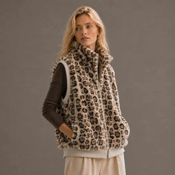 Leopard Print Sherpa Vest with a high stand collar, full zip front, and side pockets. The plush, cozy pile is finished with ribbed knit trim at the armholes and hem for a clean, structured fit. Layer it over a long sleeve tee, turtleneck, or sweater for an easy fall and winter look that works from weekend errands to holiday gatherings. Animal print and sherpa are two of the season's strongest sellers, and this vest puts both into one piece customers will reach for all season.