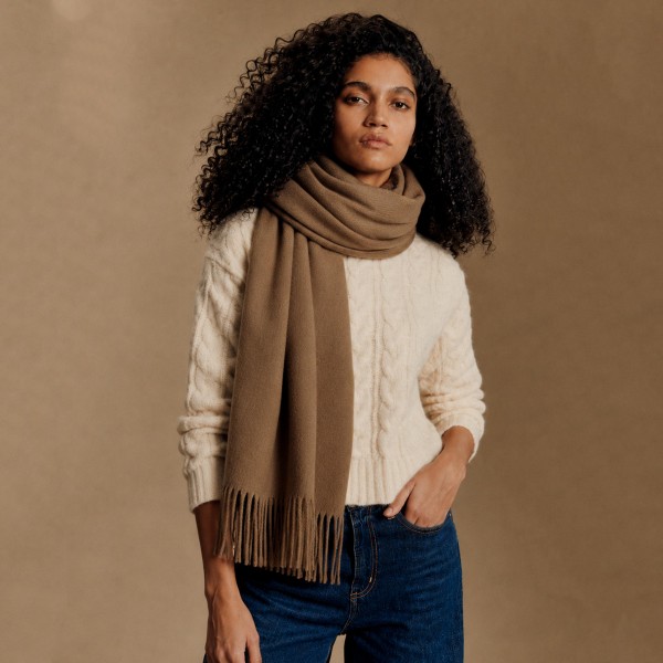 Solid Cashmere Feel Scarf in a soft, brushed blend of 83% polyester and 17% viscose. The oversized 70.9 x 27.6 inch size wraps easily around the neck or drapes over the shoulders like a shawl, finished with 3.9 inch fringe on each end. A warm, cozy layer for chilly days that pairs with coats, sweaters, and everyday outfits. Offered in a wide range of colors, this staple scarf is a must have for fall and winter displays.
