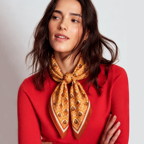 Turkey Print Square Scarf in silky 100% polyester, measuring 27.5 inches square. A repeating pattern of little turkeys is framed by a bold border for a festive fall look. Tie it at the neck over a cozy sweater for Thanksgiving dinner, Friendsgiving, and autumn gatherings, or knot it onto a handbag for a playful touch. A fun seasonal accessory that makes an easy hostess gift and impulse buy.