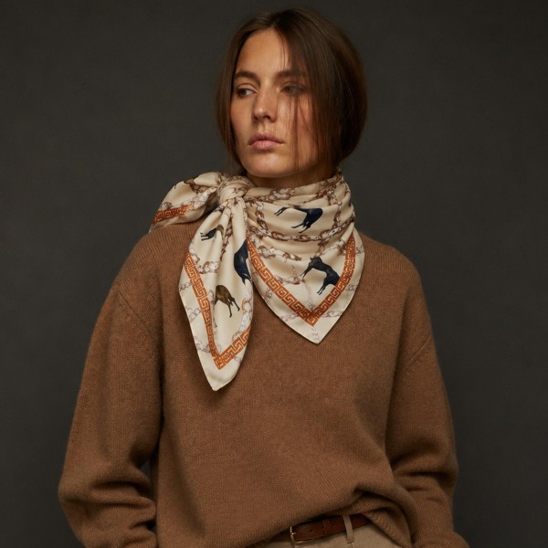 Equestrian print square scarf in a lightweight satin-feel woven, finished with a horse and bridle motif framed by a chain-link border. The generous square knots easily at the neck, ties into a ponytail or low bun, and loops onto a handbag handle for an instant refresh. Riding-inspired prints read polished with a blazer and relaxed with denim, making this a true transitional piece for fall. An easy impulse add-on that keeps the accessory wall turning.