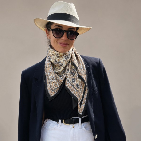 Paisley border print square scarf in a lightweight satin-feel woven, with an intricate medallion center framed by a solid contrast border. The oversized square knots at the throat, folds into a triangle over a jacket, or ties as a headscarf without adding bulk. Classic paisley is a perennial fall performer that pairs just as easily with tweed and denim as it does with knits. Strong perceived value at an impulse price point.