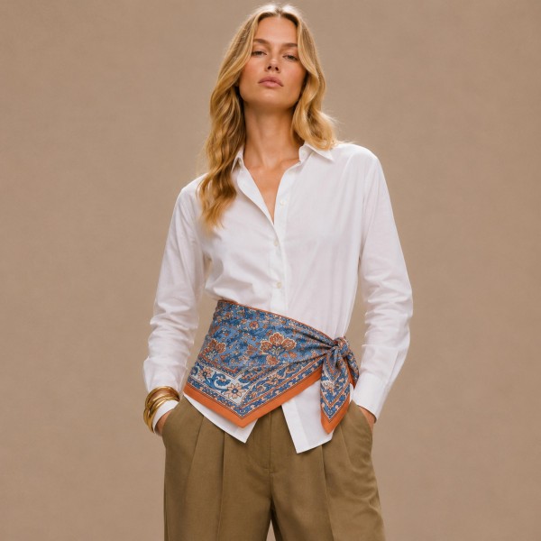 Paisley border print square scarf in a lightweight satin-feel woven, with an intricate medallion center framed by a solid contrast border. The oversized square knots at the throat, folds into a triangle over a jacket, or ties as a headscarf without adding bulk. Classic paisley is a perennial fall performer that pairs just as easily with tweed and denim as it does with knits. Strong perceived value at an impulse price point.