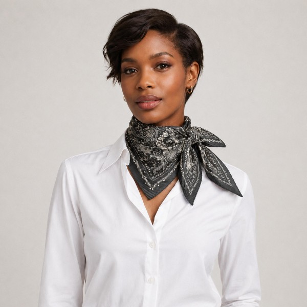 Paisley bandana print square scarf in a smooth satin-feel woven, with a dense medallion motif and a fine scalloped border. Knots neatly at the throat for a polished western-inspired look, ties into a ponytail, or loops around a handbag strap. The bandana motif is an evergreen boutique performer that sells year round and spikes every fall. Low cost, high perceived value, and an easy multiple at the register.