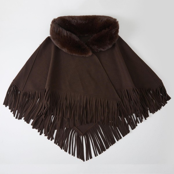 Faux Fur Collar Fringe Poncho in a soft, brushed fabric with a plush fur trimmed neckline and swingy fringe along the hem. The relaxed, open drape layers easily over sweaters, tees, and dresses for effortless warmth. Cozy enough for chilly mornings and polished enough for holiday gatherings and weekend outings. Ponchos are a dependable fall and winter seller, and the fur collar gives this style a fresh, giftable upgrade.