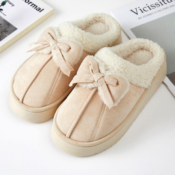 Faux Suede Bow Slippers with a plush sherpa lining, a fluffy folded cuff, and a sweet tied bow across the toe. The cushioned platform sole adds a little lift and keeps feet comfortable on hard floors, while the closed toe shape holds in warmth on chilly mornings. Packed as an assortment of sizes. Bow details are one of the most requested cozy looks this season, making these slippers an easy gift and a fast seller from fall straight through the holidays.