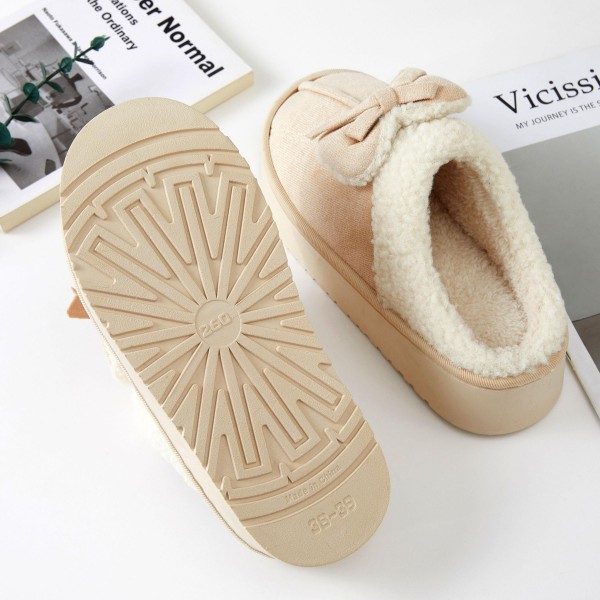 Faux Suede Bow Slippers with a plush sherpa lining, a fluffy folded cuff, and a sweet tied bow across the toe. The cushioned platform sole adds a little lift and keeps feet comfortable on hard floors, while the closed toe shape holds in warmth on chilly mornings. Packed as an assortment of sizes. Bow details are one of the most requested cozy looks this season, making these slippers an easy gift and a fast seller from fall straight through the holidays.